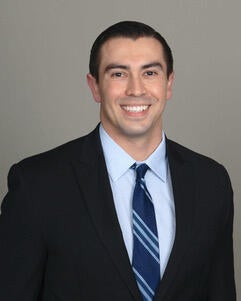 Dr. Ruiz in a suit and tie smiling for his headshot 